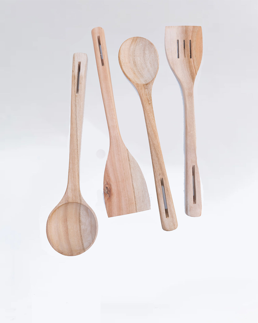 Set of four wooden kitchen utensils on a light gray background
